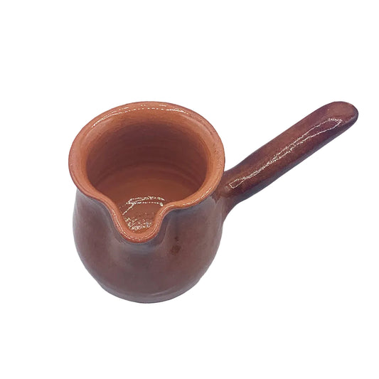 A terracotta ceramic pourer with a handle and pouring spout, shown on a plain light background.