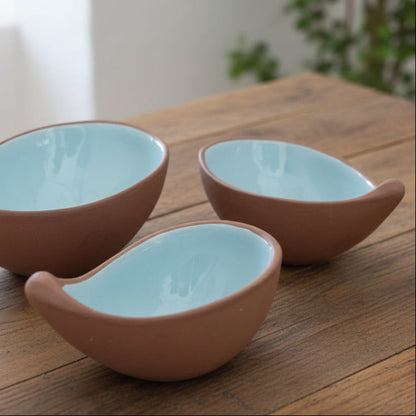 3 terracotta bowls with a blue glaze interior