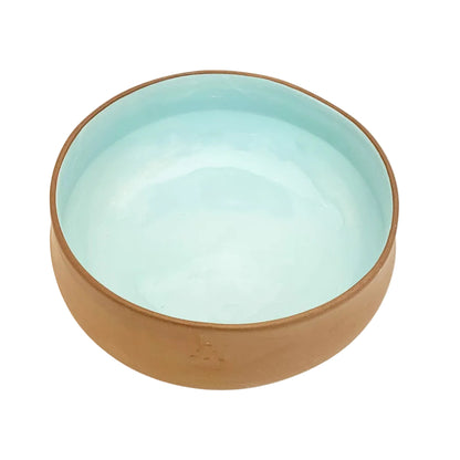 Ceramic bowl with brown exterior and light blue interior on a white background