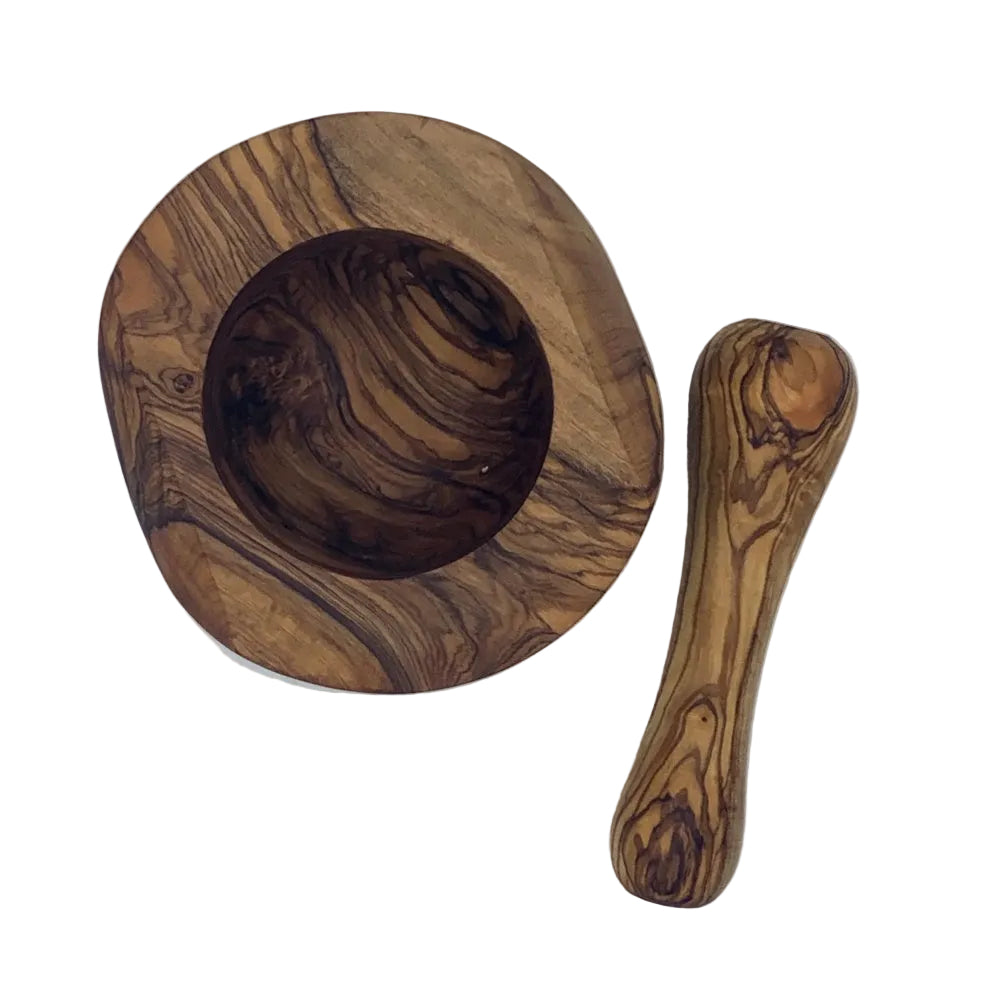 A handcrafted olive wood mortar and pestle set, photographed from an overhead angle on a white surface.